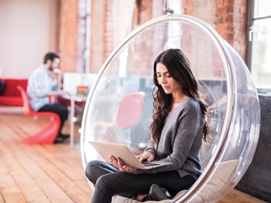 Woman sat down with laptop in an office enviroment