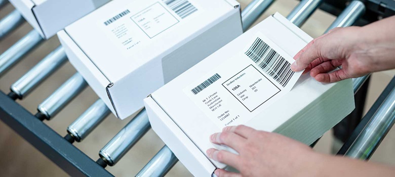 White box with delivery label being attached in fulfilment centre